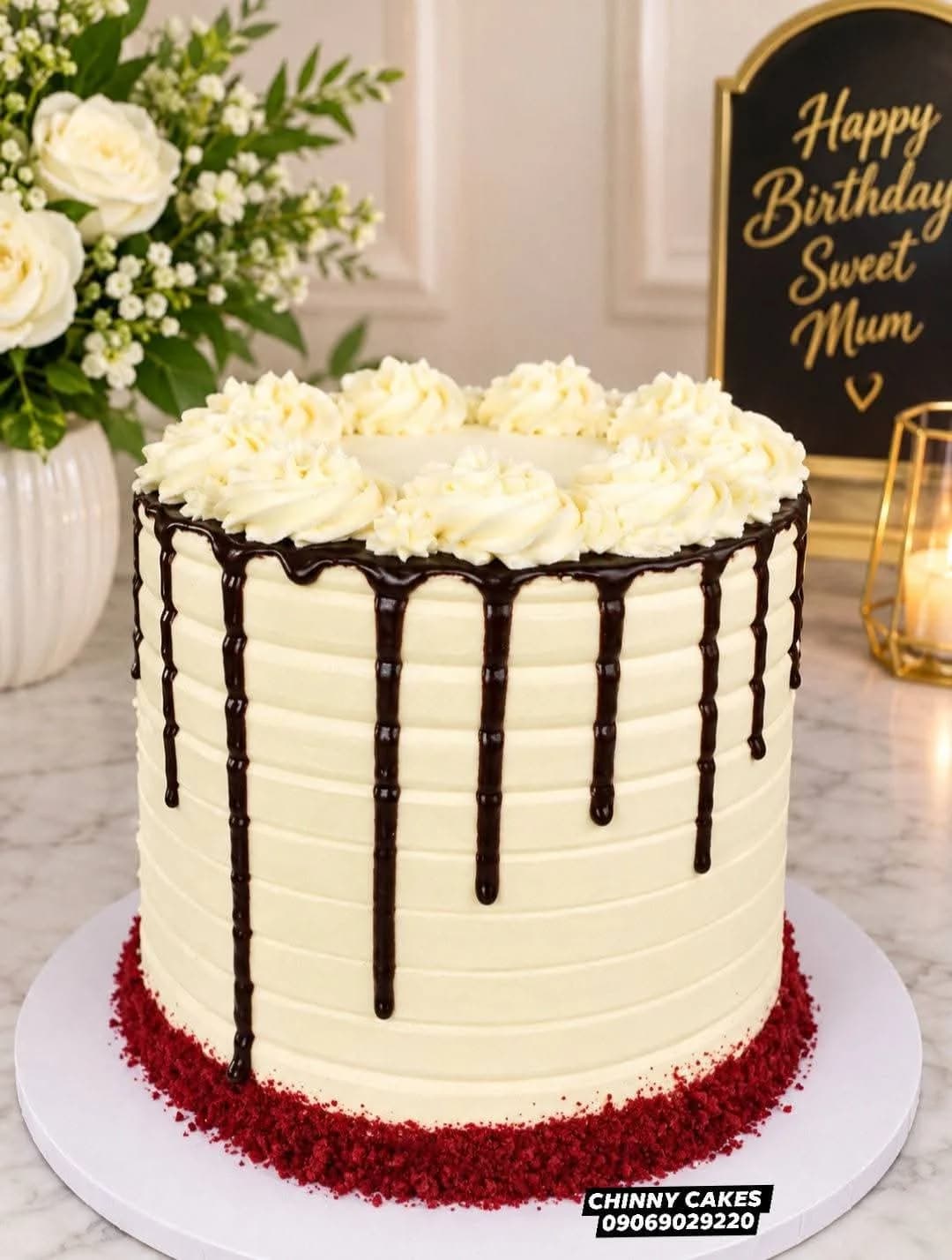 Cream birthday cake with dark chocolate drip and piped buttercream border