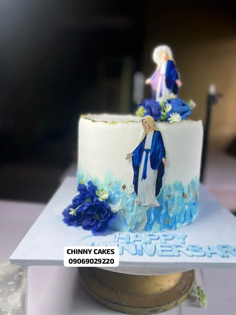 White and blue anniversary cake with floral decoration and figurine detail