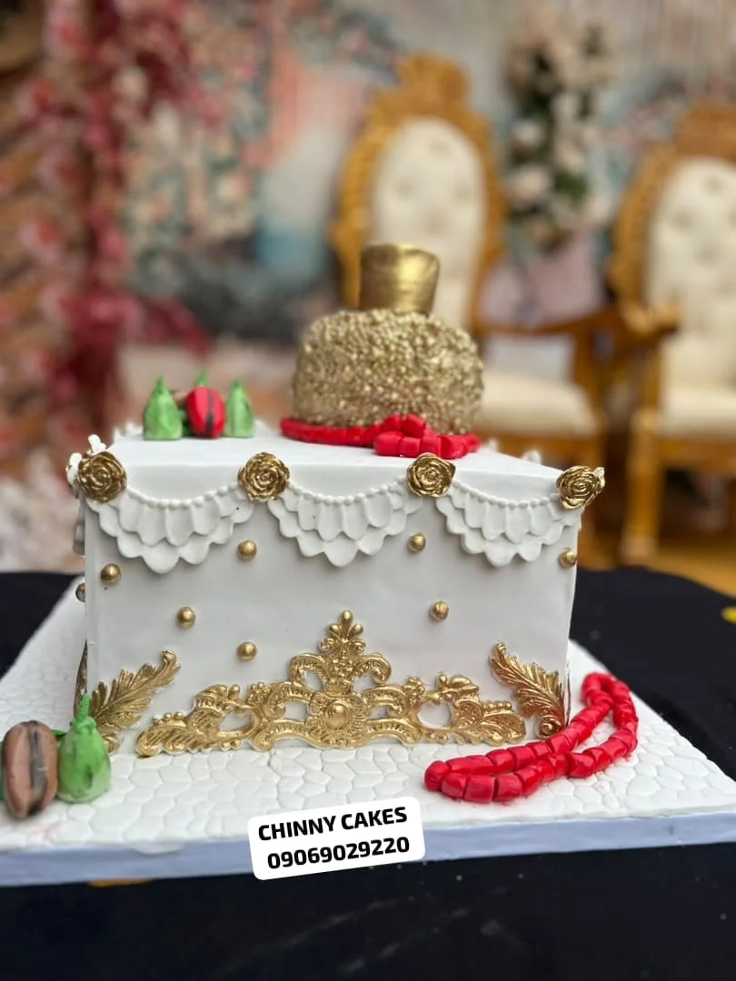 White and gold statement cake with red traditional bead decorations